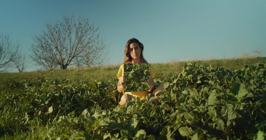 A woman is standing in a grassland area