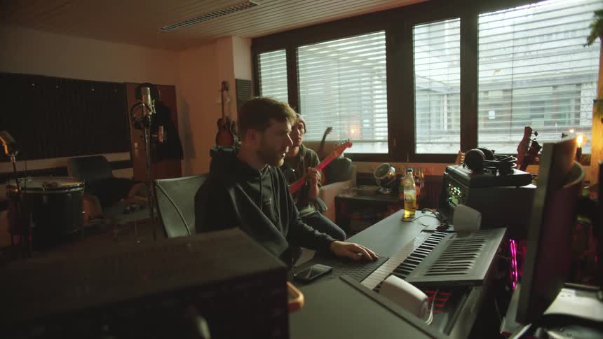 Two men work in the music studio