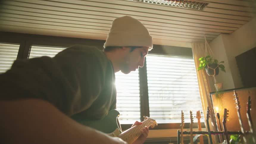 A man plays the guitar inside