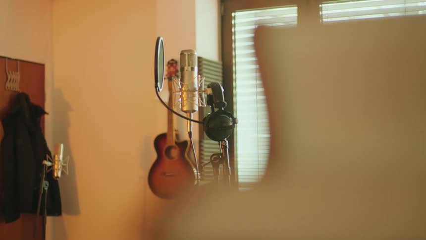 Microphone with a pop filter on a stand inside a studio