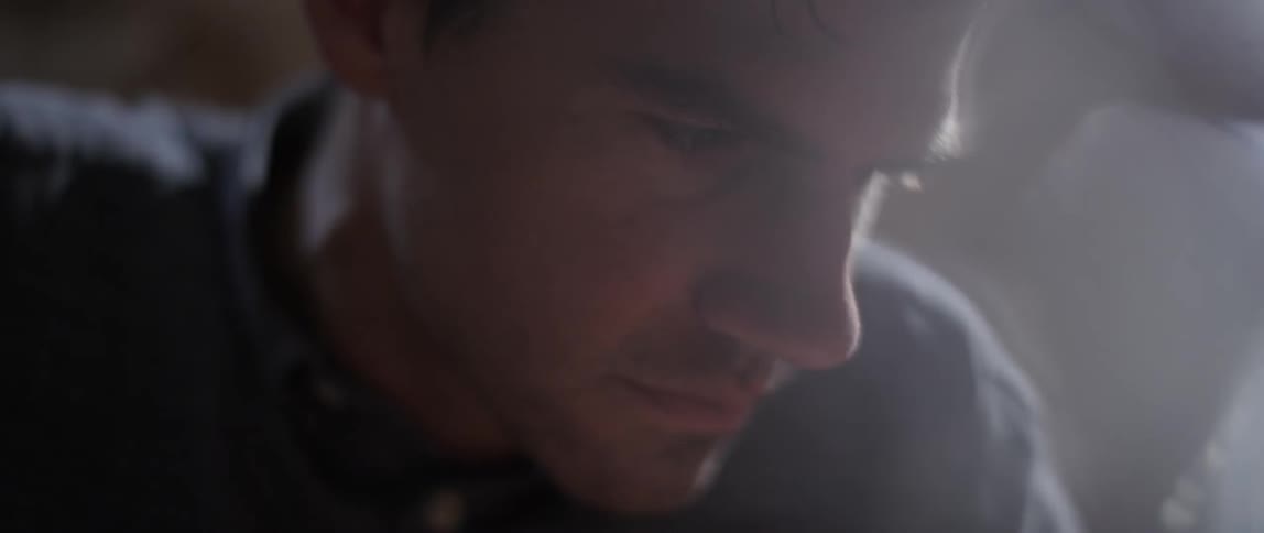 A man is looking down working on something
