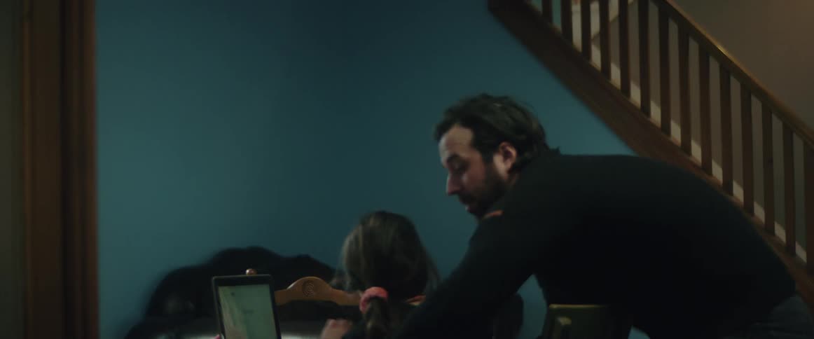 A father enters a room and playfully picks up his daughter