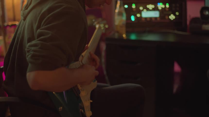 A man playing an electric guitar in a studio