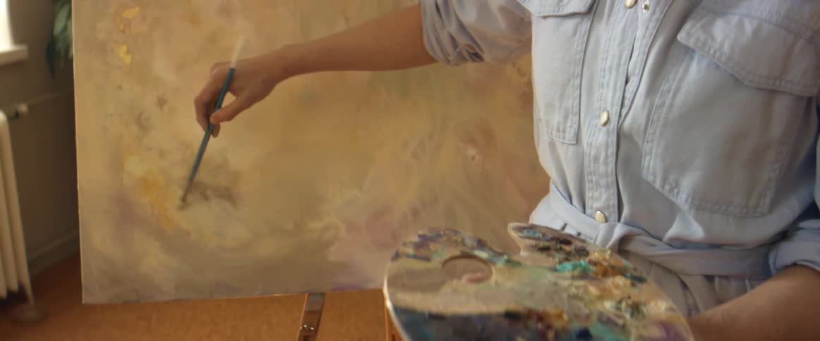 A woman paints on a canvas