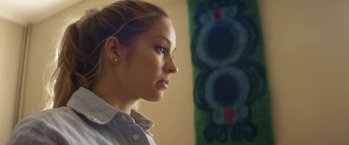 Side view of blonde woman with a ponytail and a light blue shirt