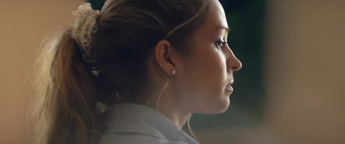 A young woman with a ponytail focuses her attention on her task