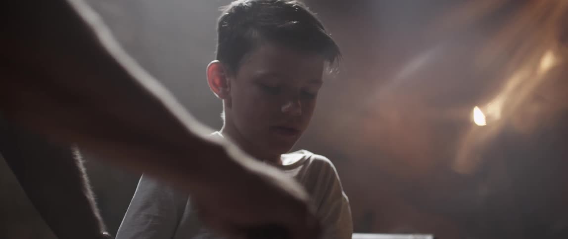 A boy is watching as a person works on something
