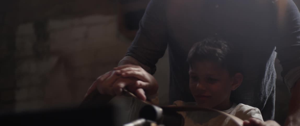 A man is working with a child in a shop