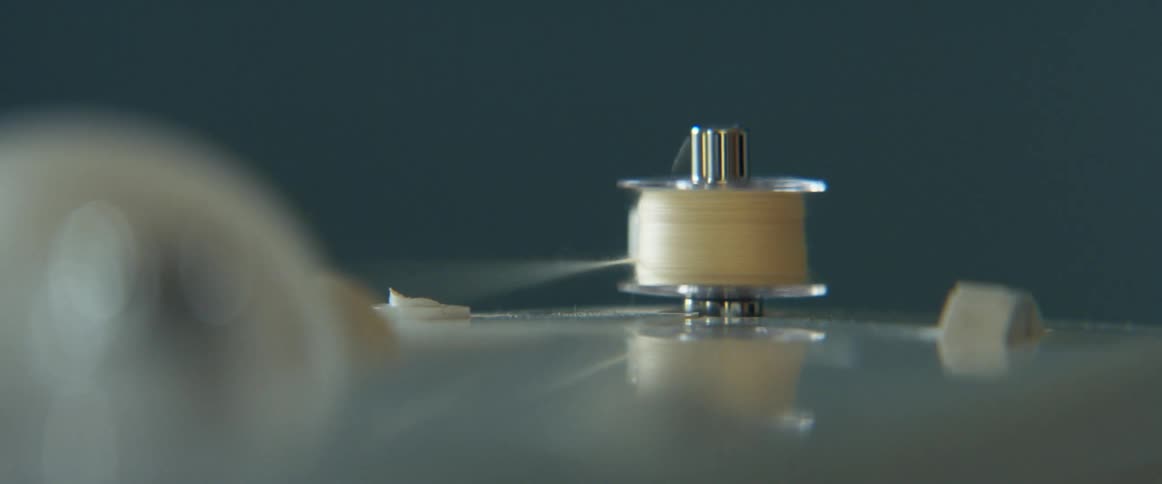 Close up of a sewing machine spinning the thread