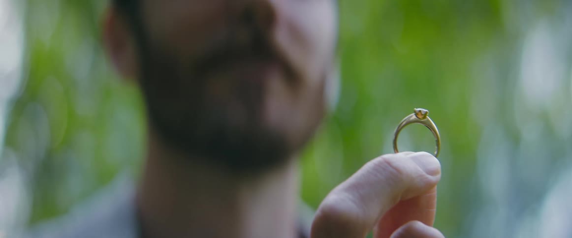 A man gets down on his knee to propose with a ring