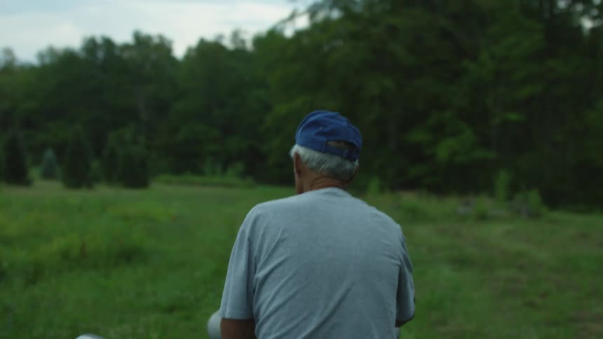 A man drives a tractor in an open rural area