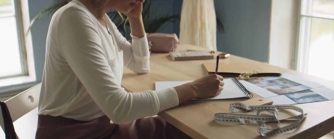 A woman is writing on a pad