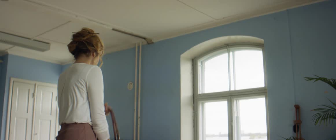 A woman entering a room and putting her purse down