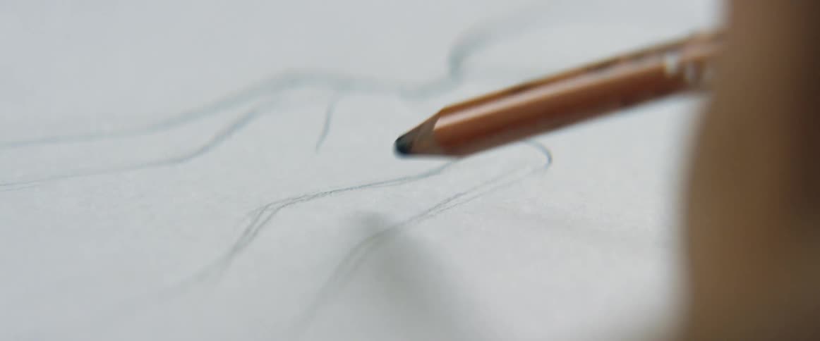 A person is drawing a figure on the paper