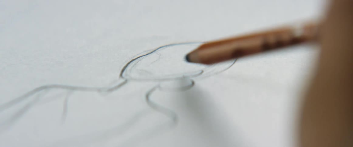 Young blonde fashion designer drawing a design on paper