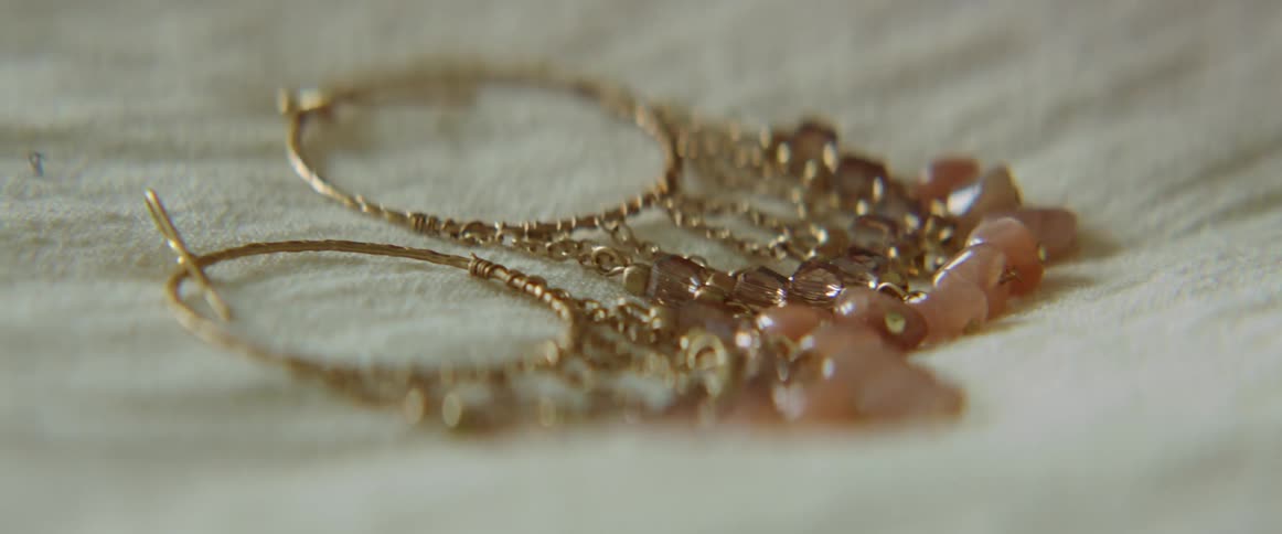 A person in a room touching earrings on a fabric