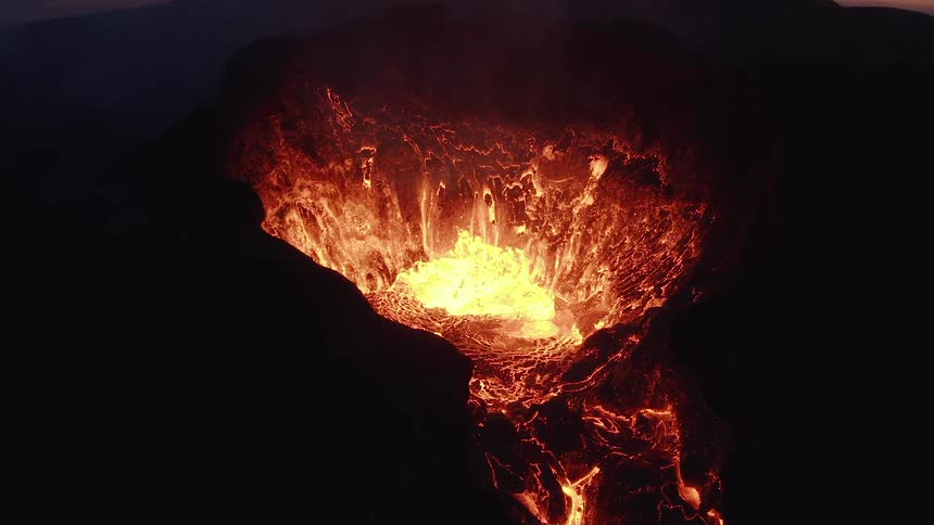 Bright lava bubbles and splashes atop an active volcano