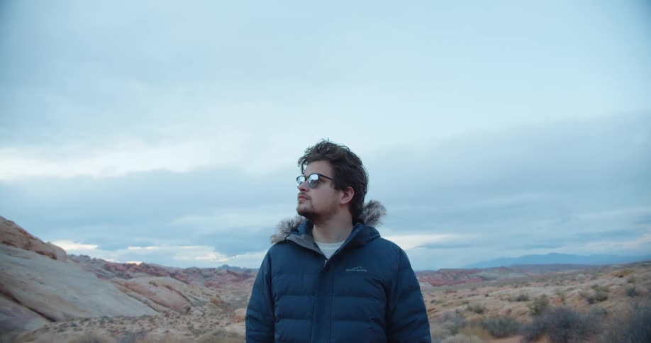 A man is looking around in the desert