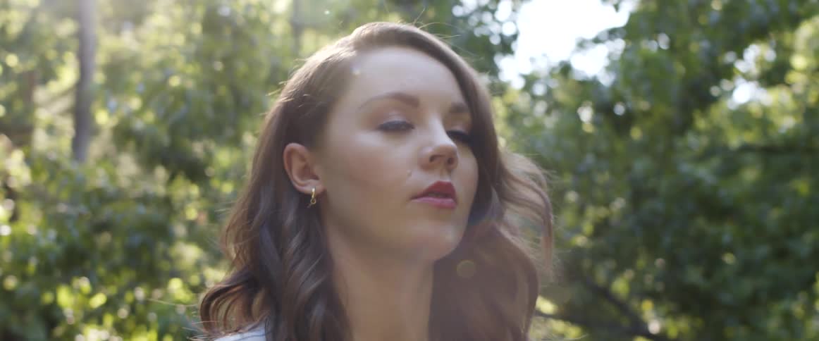 A woman walking outdoors on a sunny day