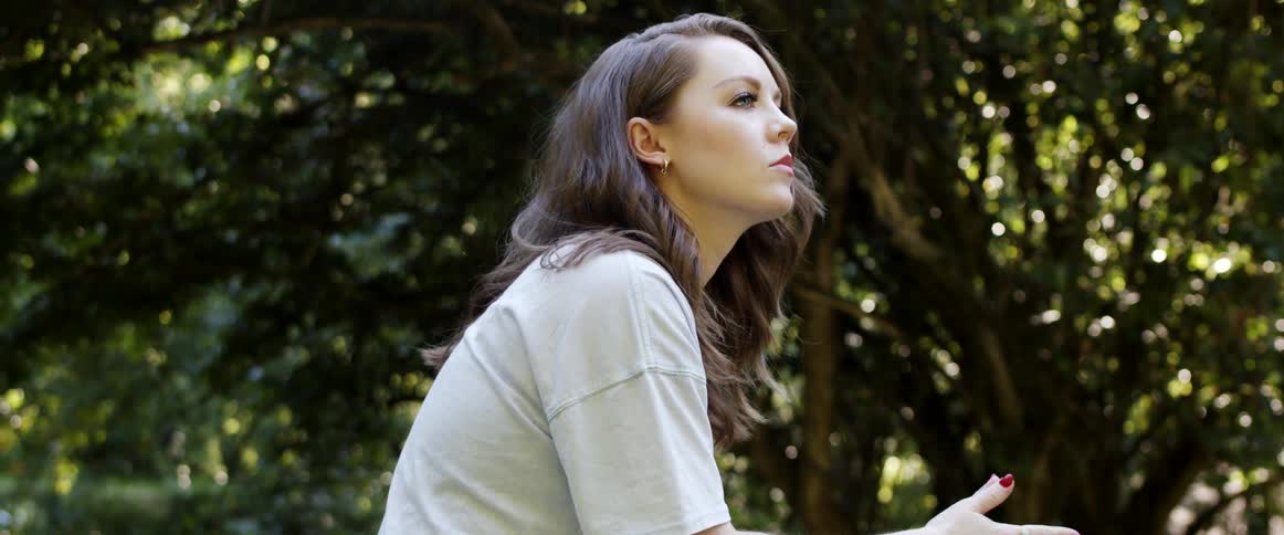 A woman sitting outside thinking