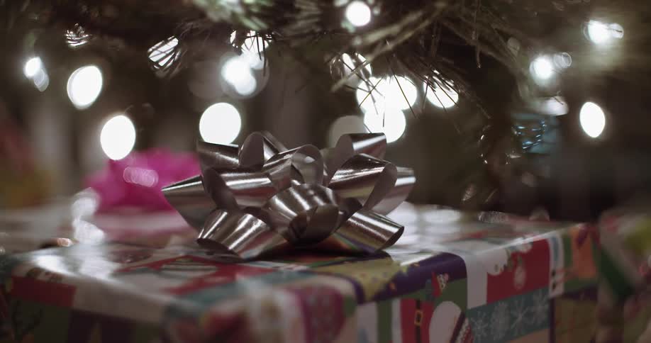 Close up of presents under a lit christmas tree