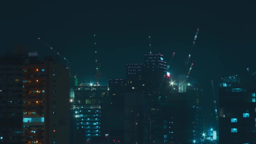 Construction cranes loom above all skyscrapers and move back and forth at night