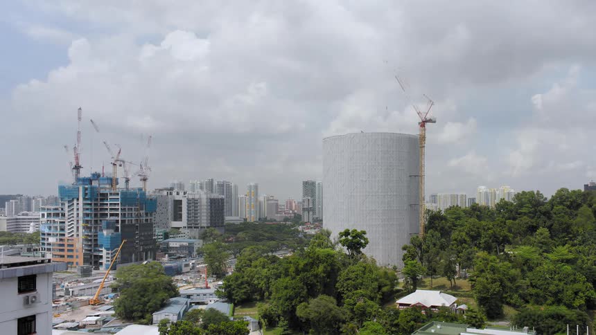 A city with buildings and trees with the sky and clouds in the background