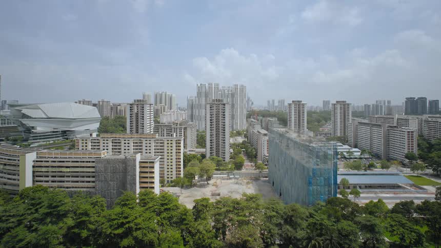 A city with buildings and trees with the sky and clouds in the background