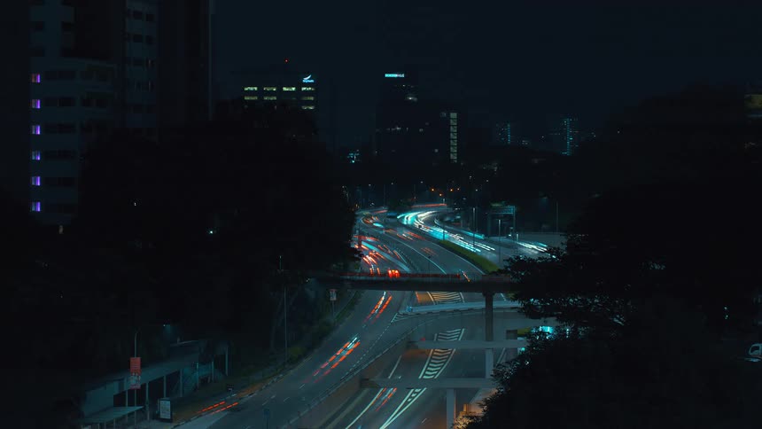 Vehicles drive on city highway at night