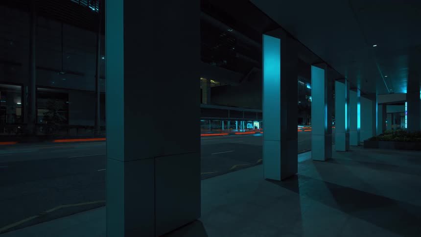 Cars pass by the buildings at night