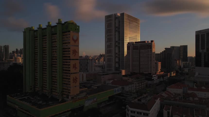 Sky brightness and sun can be seen rising in reflection on downtown building