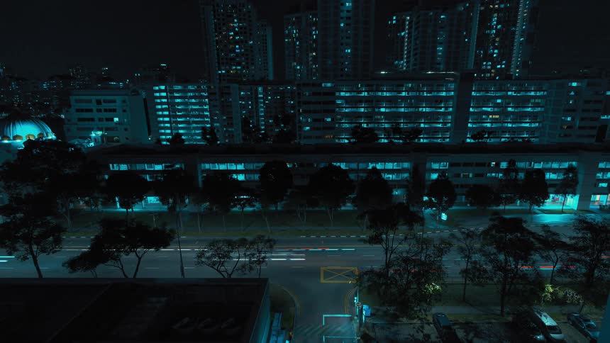 A time lapse shows the lights of cars driving quickly along a city street at night