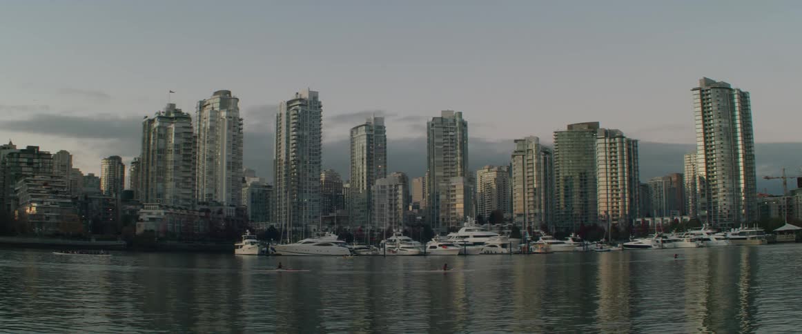 High rise condo buildings next to still water at sunset
