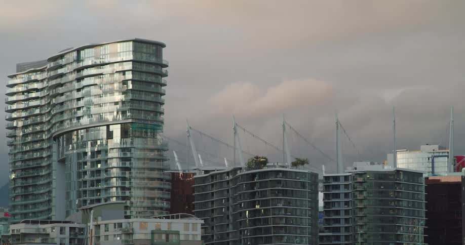 A city skyline with buildings with the sky and clouds in the background