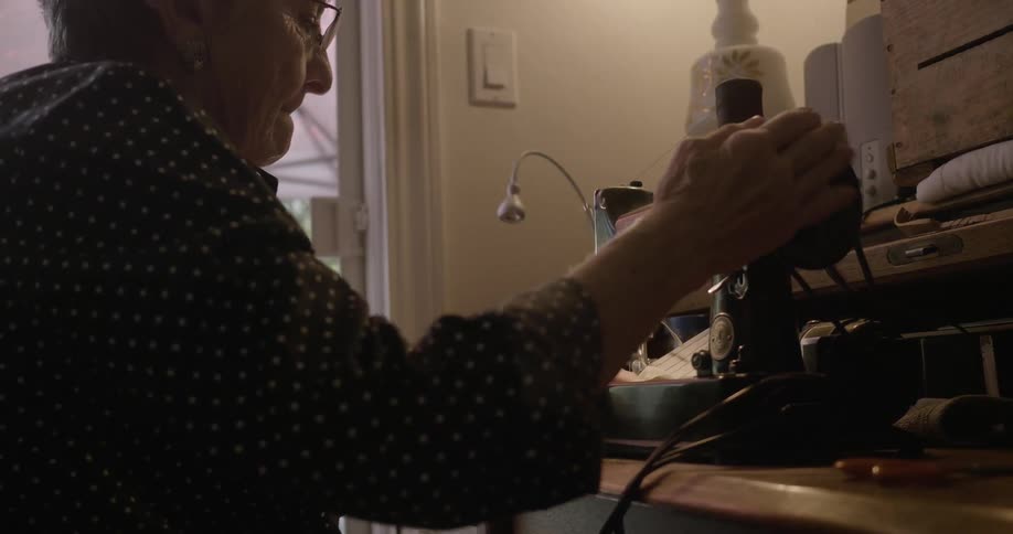 Elderly woman using her old sewing machine