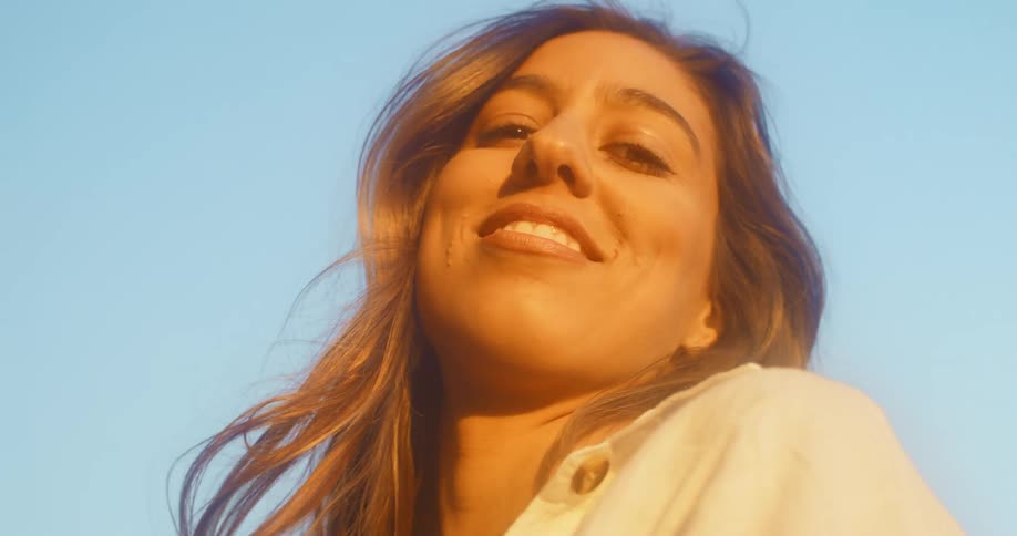 A woman is standing outdoors and smiling