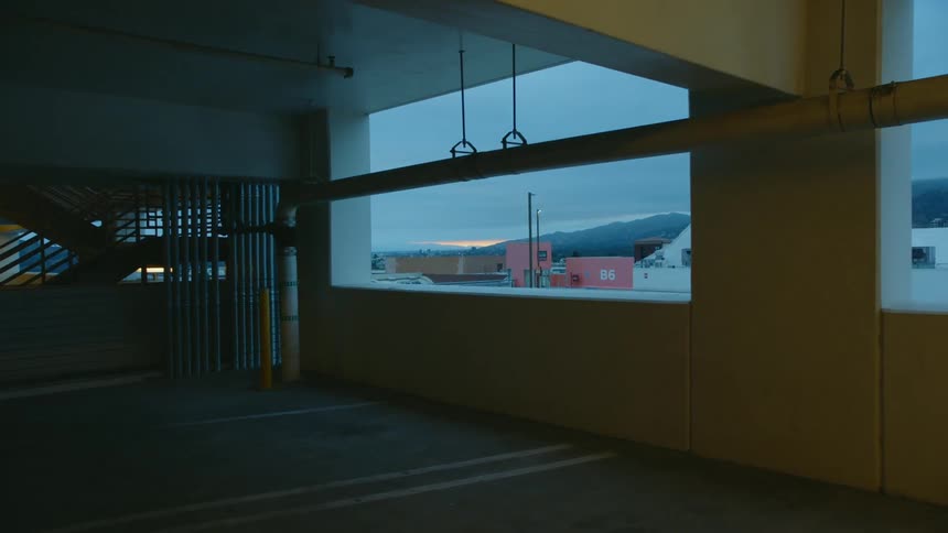 A vehicle parked outside of a parking garage and a close up of the cement in the parking garage