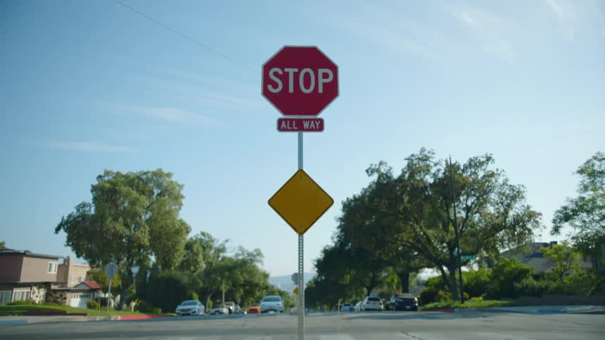 A stop sign at an intersection in a residential neighborhood during the day