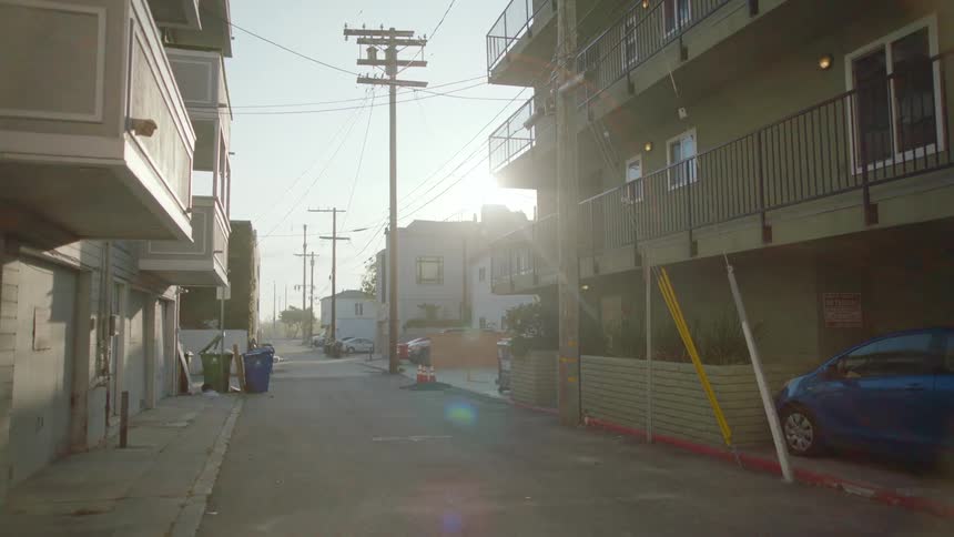 An empty road in a downtown city is displayed at dusk