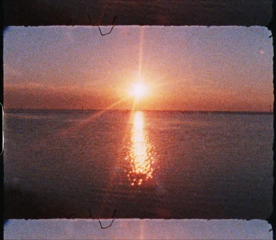Calm waves move in the ocean as the sun rises