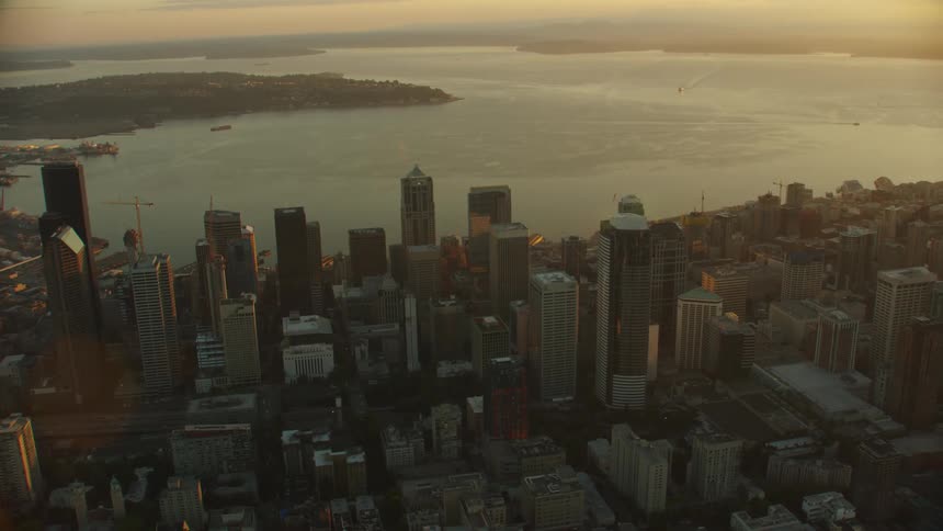City downtown skyscrapers sits across water from vegetation filled peninsula