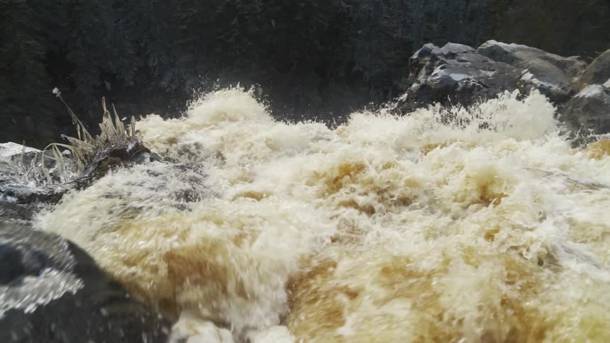 A river is flowing into a waterfall in spring