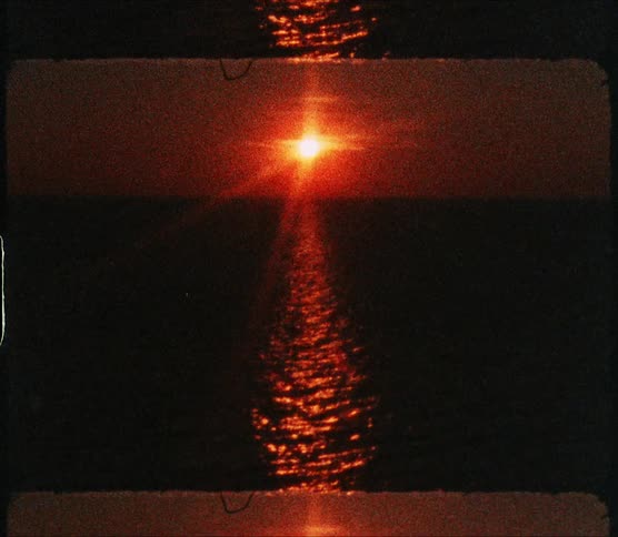 Sun reflecting off dark ocean turns landscape red