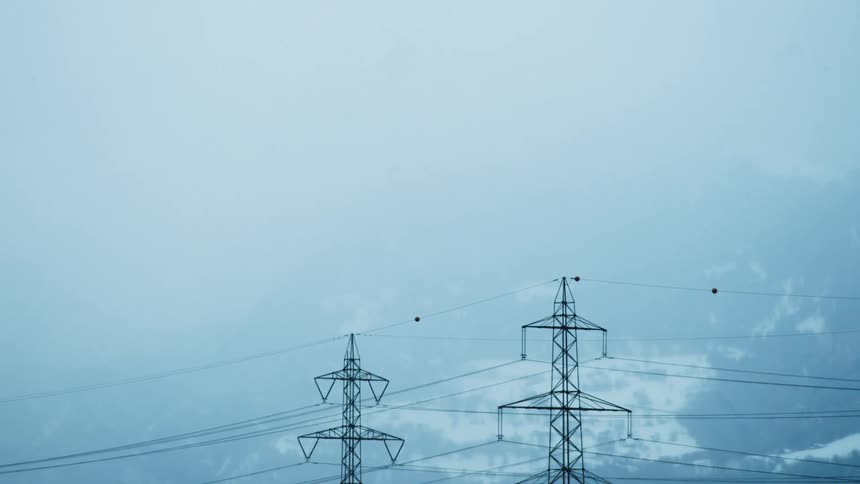 Utility towers high in the sky with scattered clouds