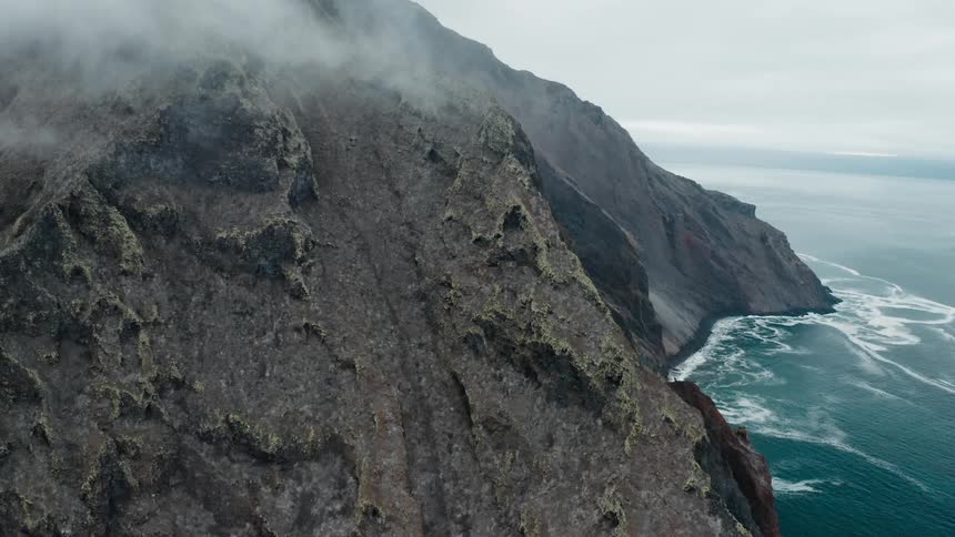 A mountain on the coast on a foggy morning