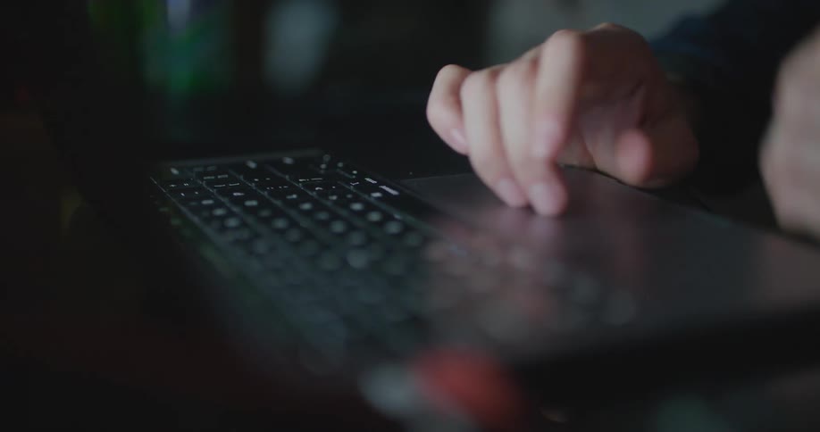 Man types on laptop keyboard