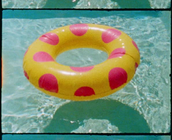 A floating toy inflatable lifesaver in a pool with rippling water