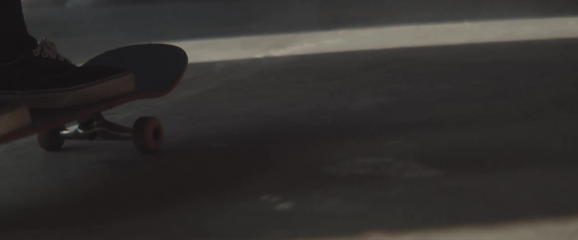 Person wearing sneakers rides a skateboard in side a building