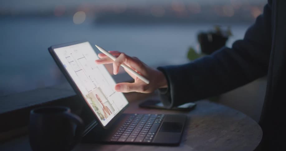 A man in an office video chats on a laptop with a woman