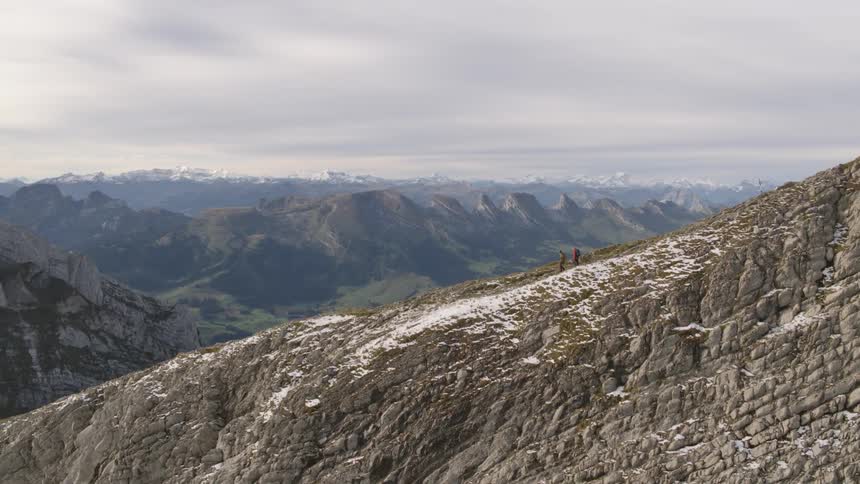 Two people hiking down a mountain